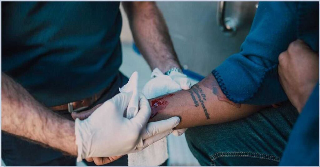 A trained first aider making wound first aid