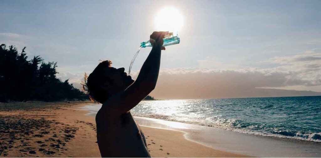 A man drinking water to protect yourself from heat stroke or sunstroke